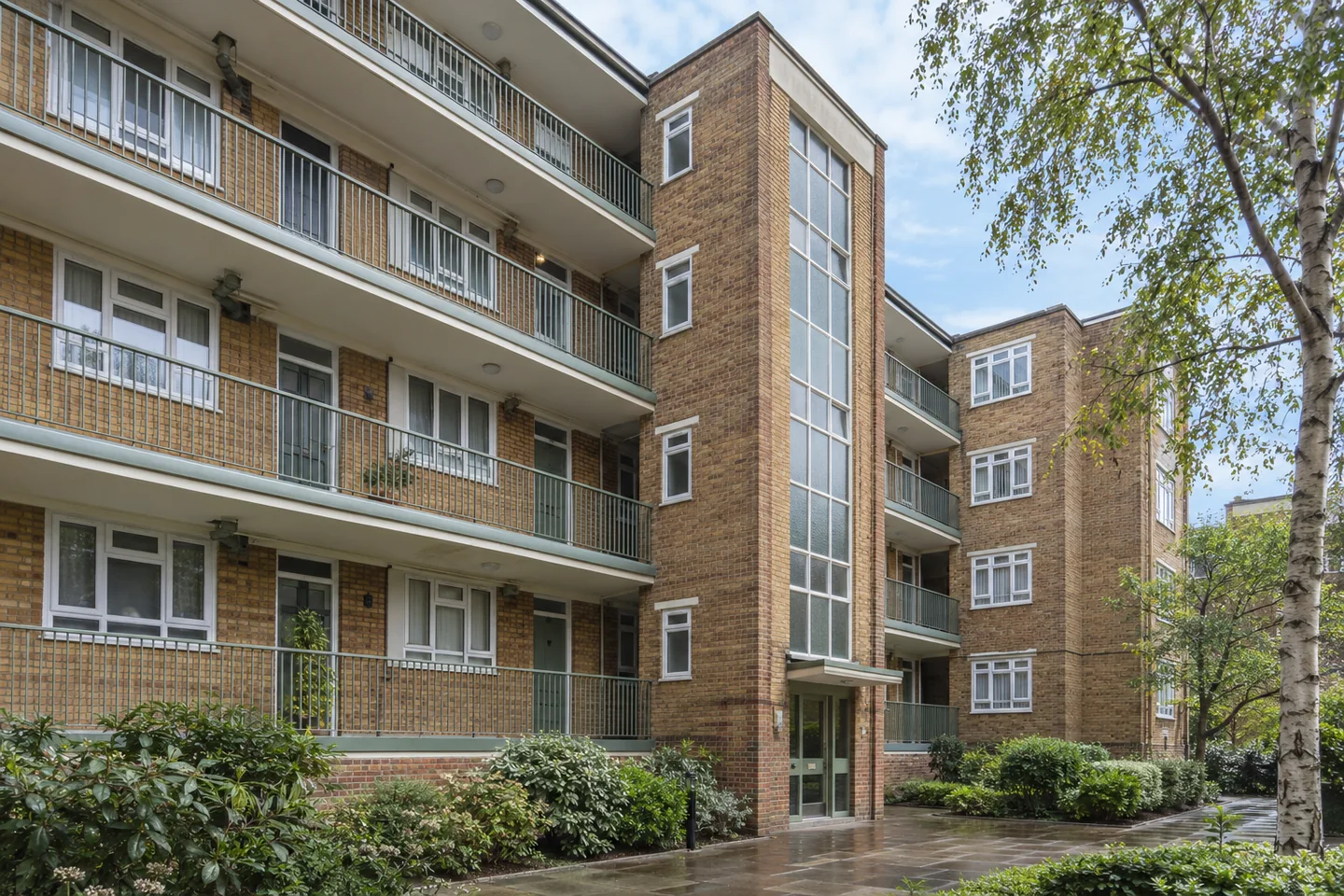 Post-war brick housing with painted balcony edges and shared stairwell entrances
